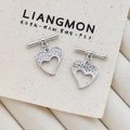 Detail of heart-shaped zircon earrings with silver metal T-bar design on canvas - Modern Heart Dangle Style