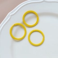 Detailed view of three bright yellow macaron heart keyrings on a white ceramic plate - 37# Large Round Ring (Single)