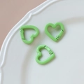 Close-up of light green heart-shaped spring clasps on a white ceramic display tray - 50# Small Heart (Single)