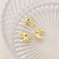 Macro shot of gold crescent moon pendants with green gemstone and micro-inlay details - 18K Gold