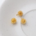 Detailed macro view of three 14k gold-plated sea urchin charms for DIY jewelry making - Gold
