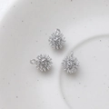 Macro view of three silver-plated starburst charms for DIY jewelry making accessories - Silver