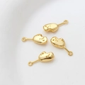Close-up of 14k gold-plated DIY jewelry charms with star texture and smooth finish - Gold Glove Style