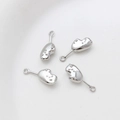 Detailed macro of four silver textured heart pendants for DIY jewelry crafting - White Gold Glove Style