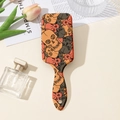 Close-up of hair brush handle with colorful skull pattern and hanging hole detail - Orange Gray Skull Print (B)