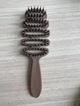 Detail view of the ventilated curved vent brush with massaged pins on wood background - Brown