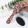 Detail of floral printed paddle brush with 3D flower and butterfly patterns on back - Pattern C