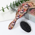 Macro detail of oval air cushion brush with floral pattern and soft massage bristles - Pattern B