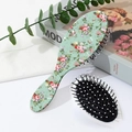 Detail view of floral print hair brush with black air cushion and massage bristles - White Floral (C)