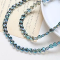 Detail von irisierenden herzförmigen Glasperlen für DIY-Schmuck mit Regenbogen-Metalleffekt - 1 Strang (ca. 86 Perlen) / Grün