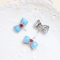 Close-up of bow-shaped jewelry accessories with blue enamel and red heart stone - Bowknot Heart Insert Pin / White K Blue