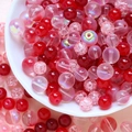 Detail of red and pink DIY crackle glass beads with AB coating in a white ceramic bowl - 75g / Red Series