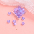 Nahaufnahme violetter durchscheinender Glasperlen mit Aufbewahrungsbox für DIY-Schmuck - Violett