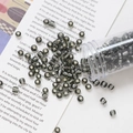Macro detail of 4mm dark grey glass beads with silver gold foil spilling from a clear tube - Dark Gray