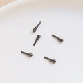Detailed close-up of five gun black metal craft pins in a white dish for jewelry making - Gun Black