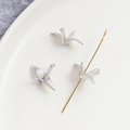 Macro shot of silver paper crane pendants with central hole for DIY jewelry making - White Gold