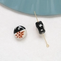 Macro detail of hand-painted ceramic beads with sun and star patterns for DIY jewelry - Sun Pentagram Style (7#)