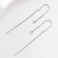 Macro detail of minimalist silver U-shaped chain earrings on white ceramic plate - White Gold Color