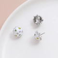 Detailed close-up of handmade enamel eggshell jewelry findings with colorful heart patterns - White Gold