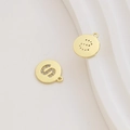 Macro detail of gold-plated letter S pendant with zircon inlay and hollow back design - Letter S / Gold
