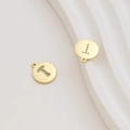 Macro detail of 18k gold plated letter T charm with cubic zirconia pavé setting - Letter T / Gold
