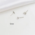 Macro detail of 5mm flat round earring posts with loops for DIY jewelry making - 5mm / White Gold