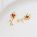 Dettaglio di orecchini a chiave con corona dorata e pietra di zircone rosso cuore - Oro K