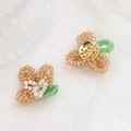 Detailed close-up of handmade beaded crystal flowers with golden metal base for DIY jewelry - Champagne