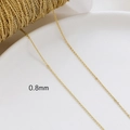 Close-up of 0.8mm gold-plated O-link chain on white ceramic for DIY jewelry making - 14K Gold Plated 0.8mm O-Chain