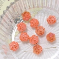 Macro shot of colorful cat paw ceramic beads for DIY jewelry making in a glass bowl - Orange