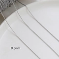 Close-up of 0.8mm silver plated chain link on white ceramic plate for DIY jewelry making - White Gold Plated 0.8mm O-Chain