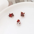 Makroaufnahme von silberfarbenen Rosenanhängern mit tiefroter Emaille für DIY-Schmuck - Mittleres Platinfarben