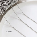 Macro shot of 1.4mm silver metal bead chain for DIY jewelry making on a ceramic plate - White Gold Plated 1.4mm Bead Chain