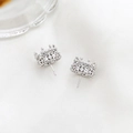 Detail view of silver crown earrings with cubic zirconia inlay on white silk fabric - Openwork Crown Style / Silver