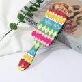Close-up of colorful Bohemian floral print on a paddle hairbrush with black massaging pins - Red Blue Ethnic (C)