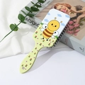 Gros plan d'une brosse à cheveux de massage à coussin d'air avec motif abeille et fleurs - Style Abeille Paysage Prairie (A)