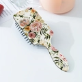 Detail of floral printed air cushion hairbrush with black massage bristles on white surface - Cream Pink Yellow Rose Style (B)