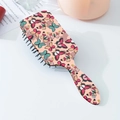 Détail de la brosse à cheveux carrée avec imprimés papillons colorés et manche ergonomique - Style Papillon Coloré (A)