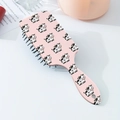 Close-up of the pink cartoon cow pattern on the portable air cushion hairbrush handle - Pink Cow Pattern (A)