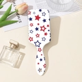 Detailed macro view of white hairbrush featuring red and blue star patterns on cushion - Pentagram Star Print Style (B#)