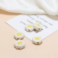 Detailed view of white ceramic daisy beads with yellow centers for DIY jewelry making - White Large Flower Yellow Center