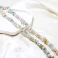 Detail view of colorful irregular natural crystal stone beads on a white tray - 1 Piece / Multicolor