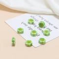Close-up of light green ceramic flower beads with yellow smiley face for DIY jewelry - Green Smiley Small Flower