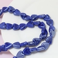 Macro shot of cobalt blue heart-shaped ceramic beads for DIY jewelry making and crafts - Dark Blue