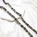 Detailed macro view of polished irregular natural green crystal beads on silk background - 1 Piece / Grey & Black