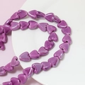 Detailed view of glossy magenta heart-shaped ceramic beads for DIY jewelry making - Purple