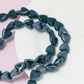 Macro detail of glossy dark green heart-shaped ceramic beads for DIY jewelry making - Brown