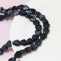 Close-up of polished black heart-shaped ceramic beads for DIY jewelry making - Black