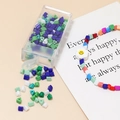 Detail of 4mm assorted beads in a box with a floral smiley pendant for DIY jewelry making - 10g Per Box / Green Purple Mix
