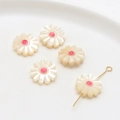 Macro view of five natural mother of pearl daisy charms with central holes for DIY jewelry - Pink Center